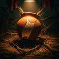 An ancient, gold-repaired kintsugi pot being lifted from a dark, intricate tangle.