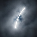 An abstract image showing swirling grey mist being pierced by a brilliant white light.
