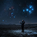 A person stands in a frozen landscape at night, looking up at the constellations of Orion and Pleiades in a star-filled sky.