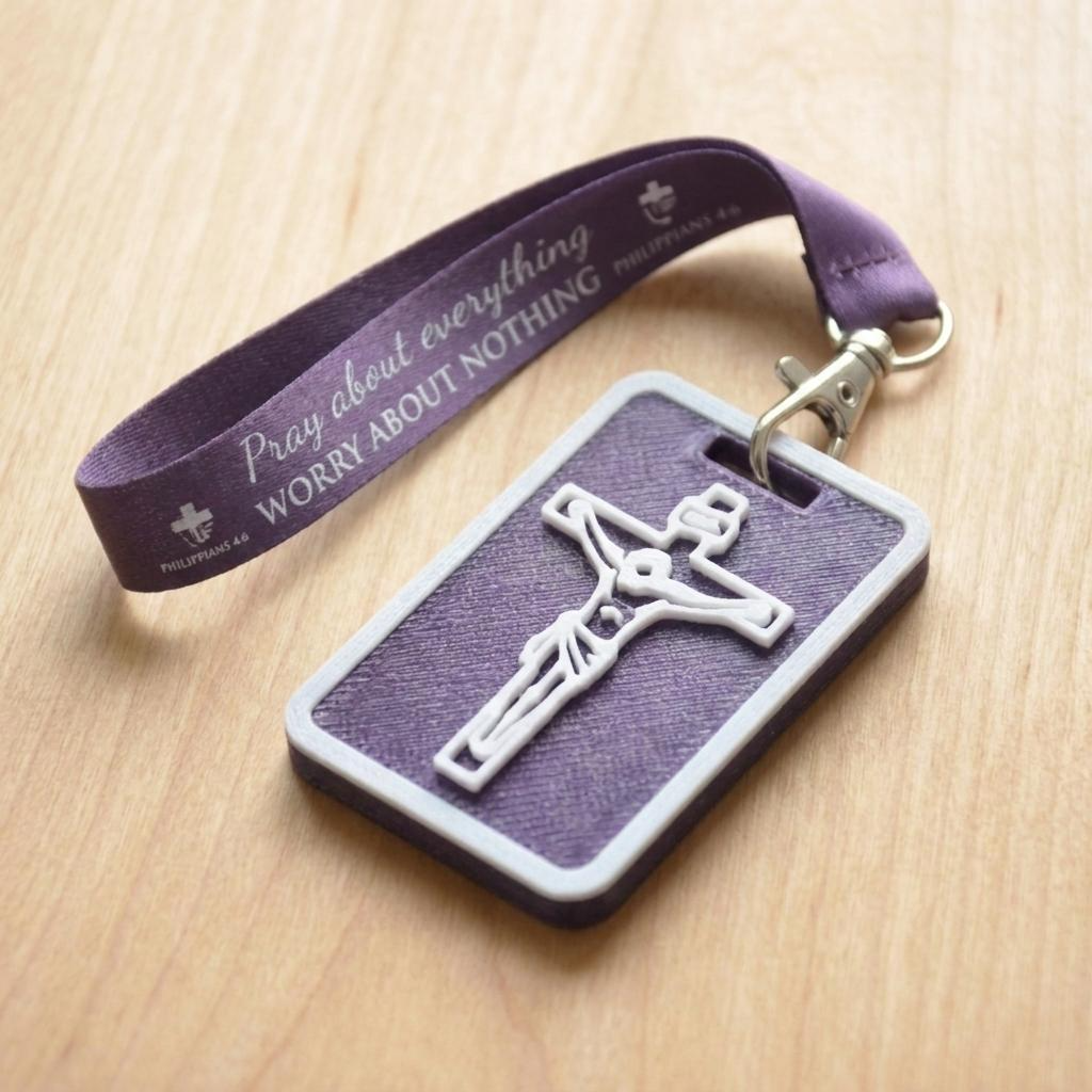A 3D-printed Eben Tag in Metallic Purple featuring a raised crucifix design. This NFC-enabled spiritual touchpoint includes a white border and is attached to a fabric lanyard printed with scripture, designed to trigger the Daily Eb devotional.