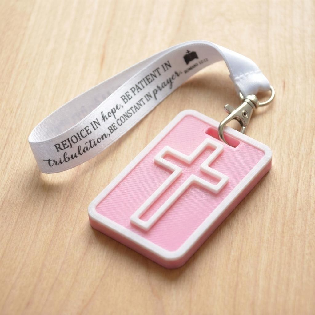 A 3D-printed Eben Tag in Pink featuring a raised cross design. This NFC-enabled spiritual touchpoint includes a white border and is attached to a fabric lanyard printed with scripture, designed to trigger the Daily Eb devotional.