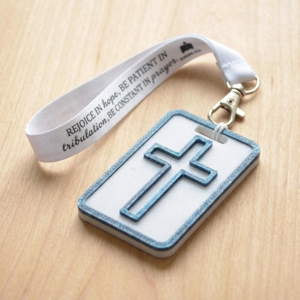 A 3D-printed Eben Tag in White and Blue featuring a raised cross design. This NFC-enabled spiritual touchpoint includes a metallic blue border and is attached to a fabric lanyard printed with scripture, designed to trigger the Daily Eb devotional.