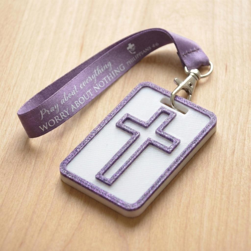 A 3D-printed Eben Tag in White and Purple featuring a raised cross design. This NFC-enabled spiritual touchpoint includes a metallic purple border and is attached to a fabric lanyard printed with scripture, designed to trigger the Daily Eb devotional.