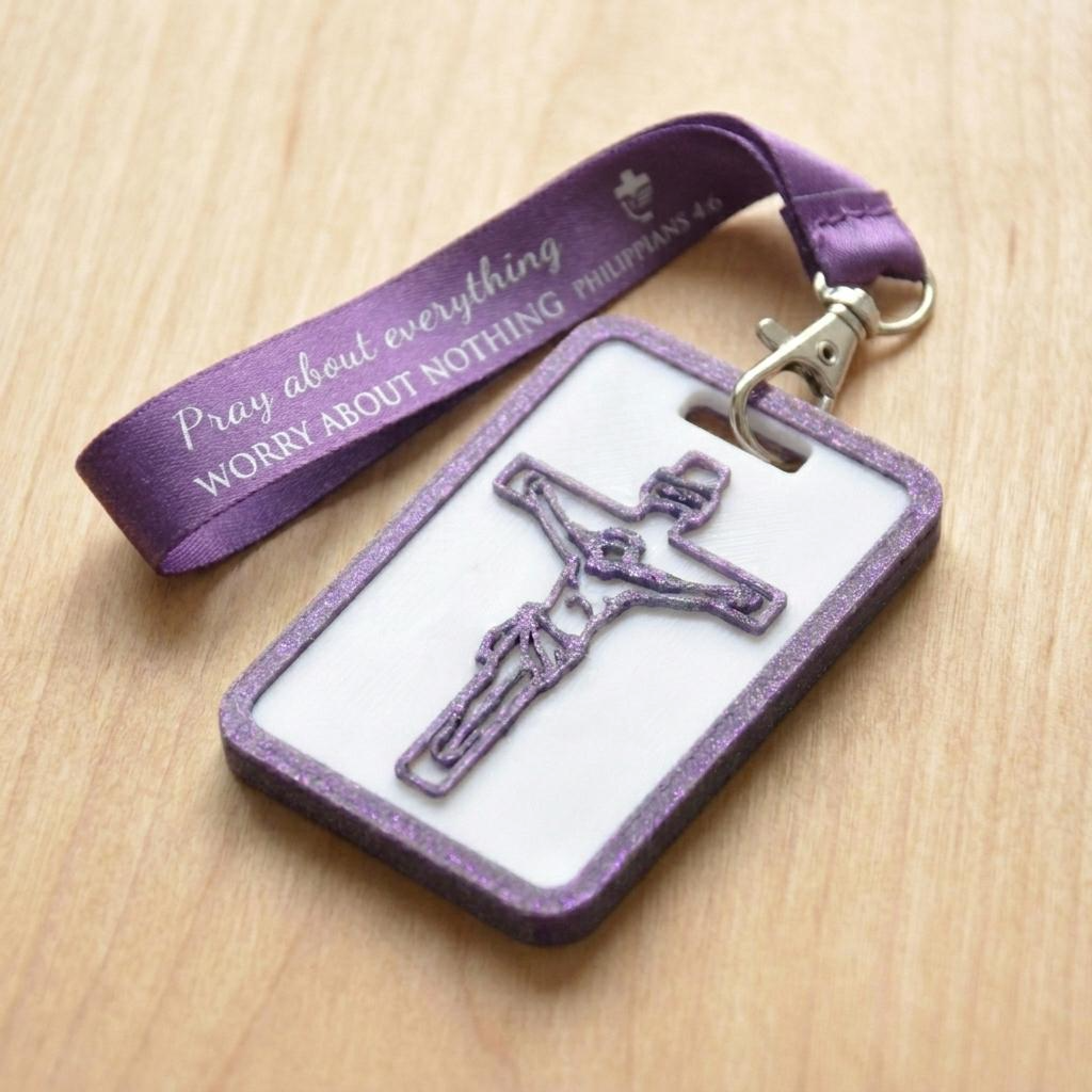 A 3D-printed Eben Tag in White and Purple featuring a raised crucifix design. This NFC-enabled spiritual touchpoint includes a Metallic Purple border and is attached to a fabric lanyard printed with scripture, designed to trigger the Daily Eb devotional.